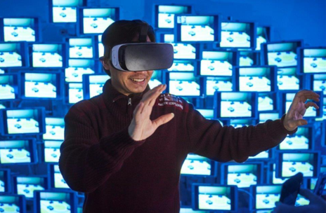  Mann mit VR-Brille vor blauen Screens